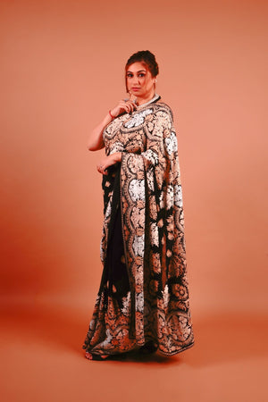 Woman wearing a patterned dress against an orange background