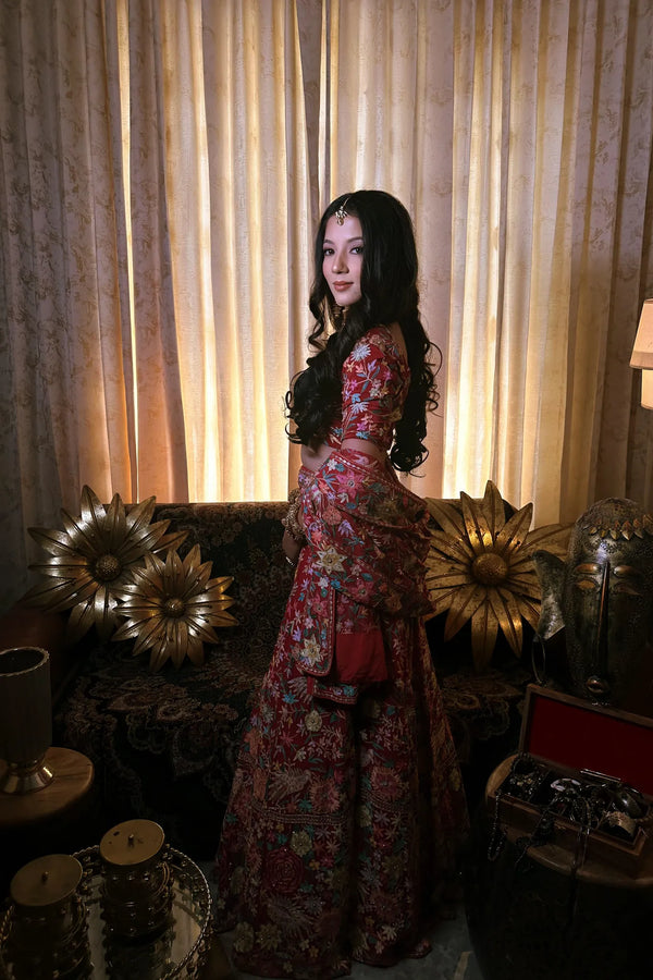 Woman in a floral dress standing in a room with decorative lighting and furniture.