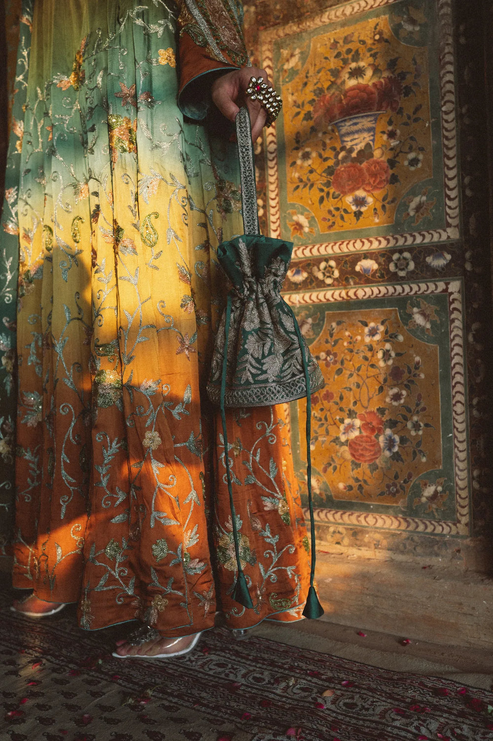 Woman in a traditional outfit with floral patterns in an ornate interior setting