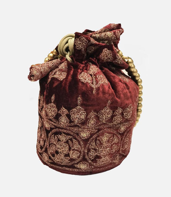 Decorative red velvet bag with gold embroidery on a white background