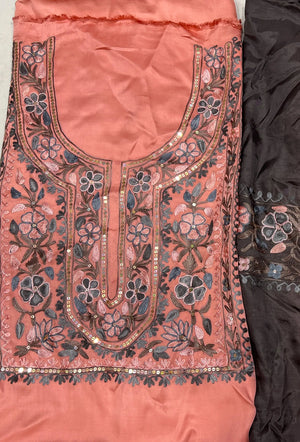 #Peach Two pieces of fabric, one with a floral Aari and sequence work in the center and the other with a border featuring the same style of work.
