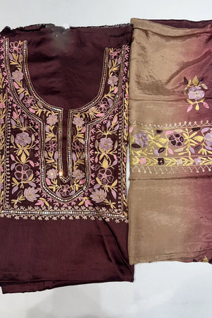 #Wine Two pieces of fabric, one with a floral Aari and sequence work in the center and the other with a border featuring the same style of work.