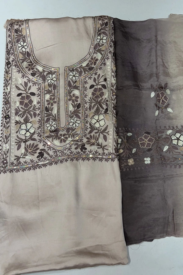 #Cream Embroidered fabric with floral patterns on a plain background