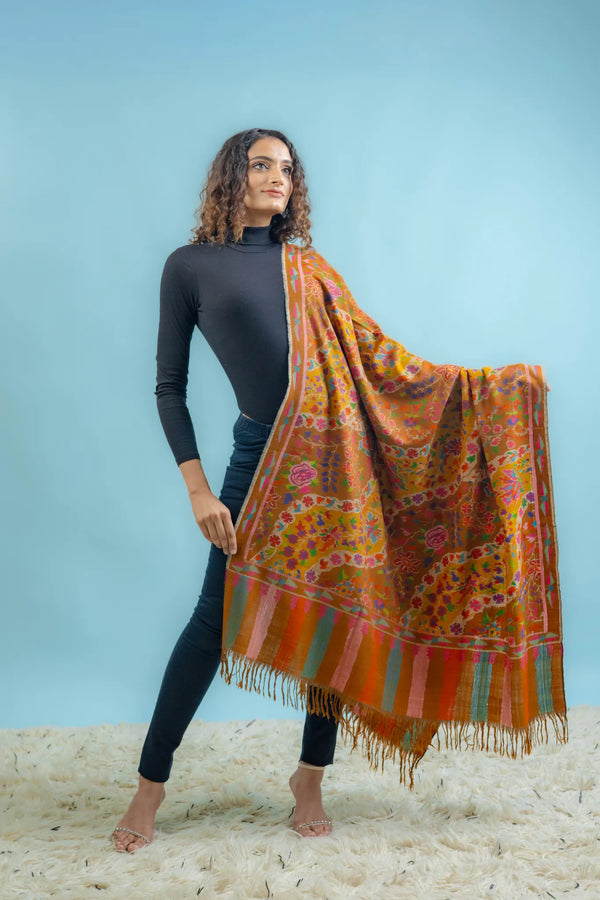 Close-up of hand Kani weave on mustard Pashmina shawl showing interlocked multi-coloured floral motifs