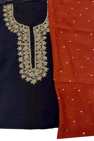 #Black - Flat lay detail of gold tilla neckline embroidery on black base alongside rust dupatta with scattered gold embroidery
