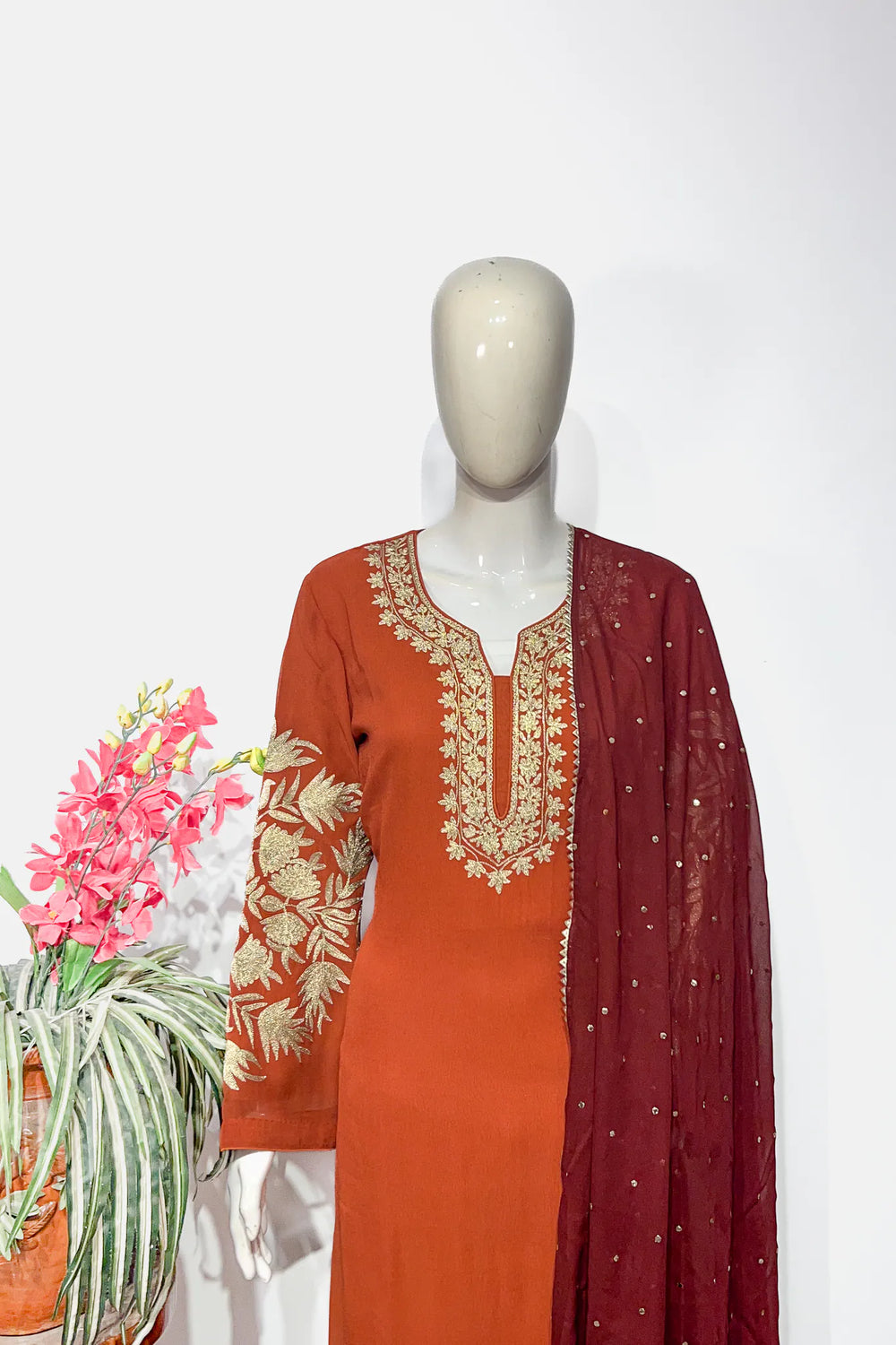 #Rust - Front view of rust viscose georgette kurta with gold tilla neck and sleeve embroidery, maroon dupatta draped to side