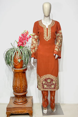 #Rust - Mannequin wearing rust tilla suit set showing full-length kurta with round-neck gold embroidery and embroidered sleeves