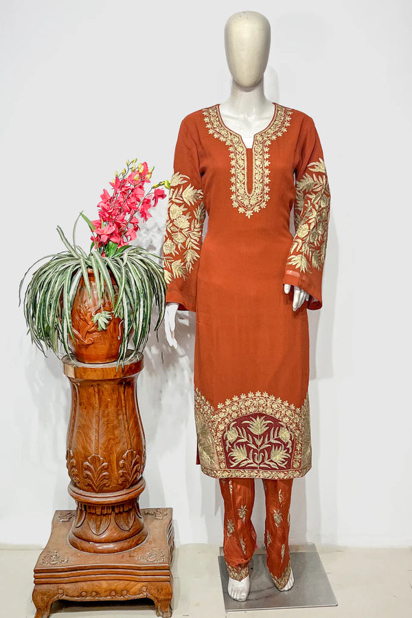 #Rust - Mannequin wearing rust tilla suit set showing full-length kurta with round-neck gold embroidery and embroidered sleeves