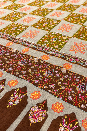 Close-up of a patchwork quilt with floral and geometric patterns.