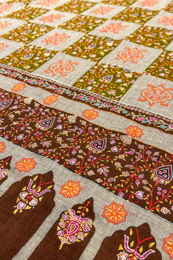 Close-up of a patchwork quilt with floral and geometric patterns.