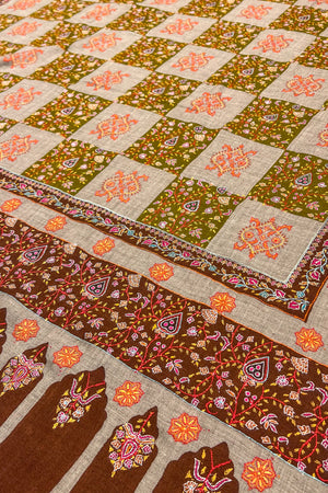 Colorful quilt with intricate patterns on a beige background