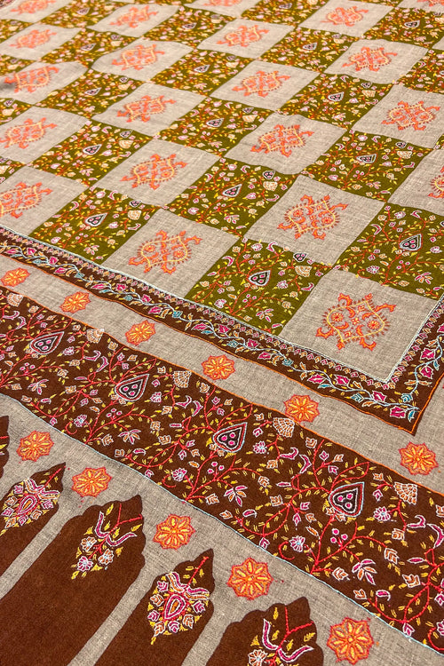 Colorful quilt with intricate patterns on a beige background