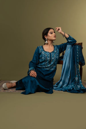 #TealBlue Woman in a blue traditional outfit with a matching dupatta on a green background