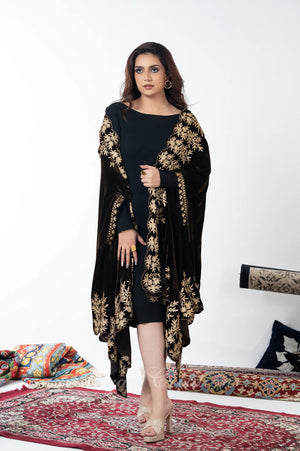 #DarkBrown Woman wearing a black outfit with gold floral patterns on a white background