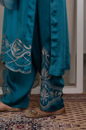 #OmbreSky&PeacockBlue - Close-up of peacock-blue straight pants ankles showing silver zari large paisley and leaf motif embroidery