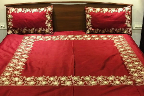 #Maroon Red bedspread with gold embroidery on a wooden bed