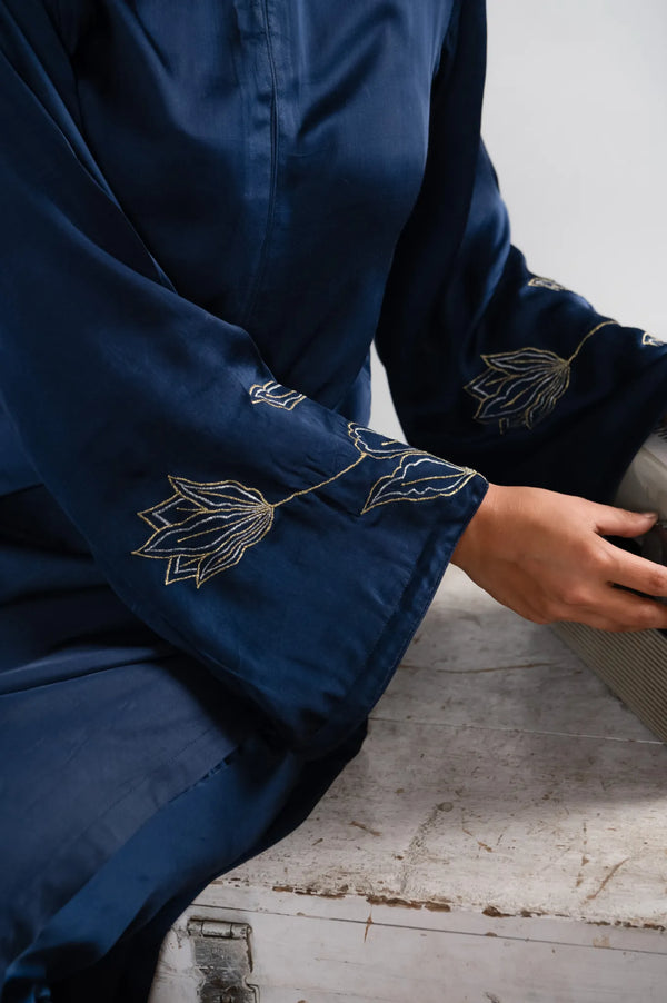 Navy blue garment with floral embroidery on a white background