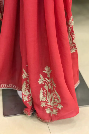 #Pink fabric with gold embroidery on a flat surface