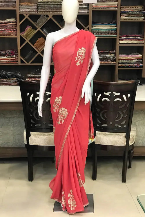 #Pink saree with gold patterns on a mannequin in a store setting