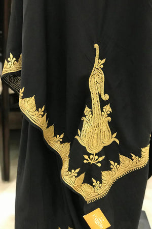 #Black fabric with gold embroidery on a blurred background