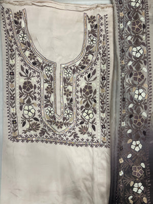 #Cream Embroidered fabric with floral patterns on a plain background