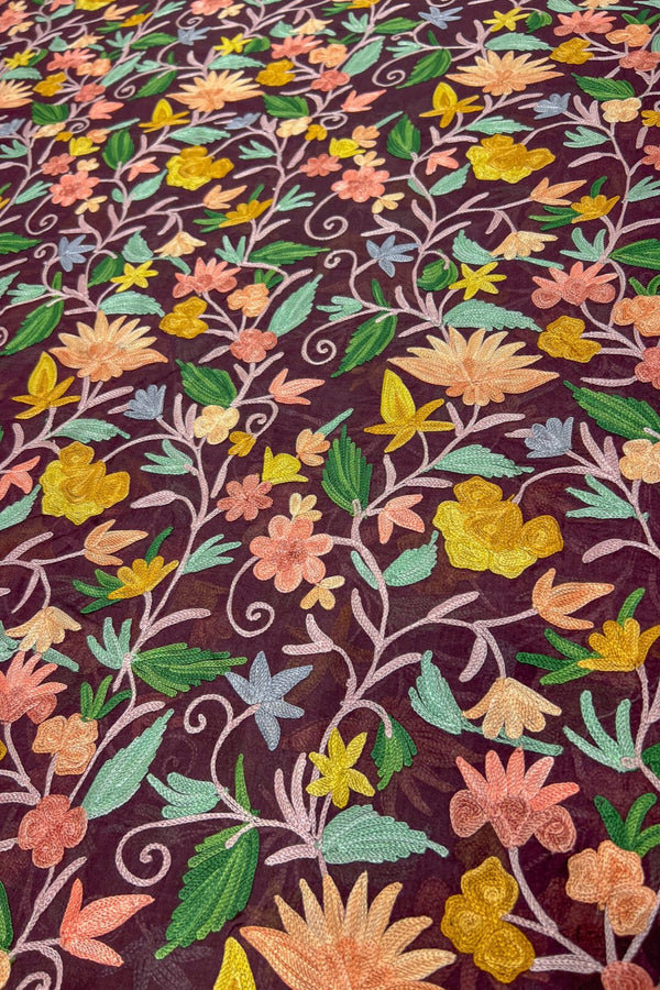 Floral patterned fabric with colorful flowers and leaves on a dark background