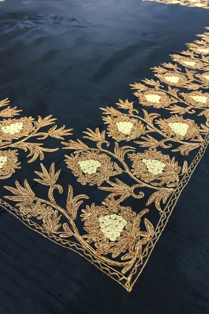 #Navyblue bedspread with gold embroidery on a bed with matching pillows.