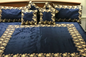 #Navyblue bedding set with decorative pillows on a bed.
