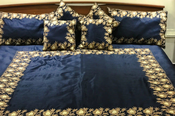 #Navyblue bedding set with decorative pillows on a bed.