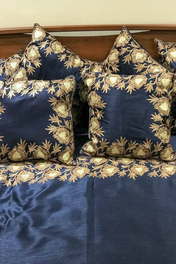 #Navyblue Set of blue cushions with gold embroidery on a bed