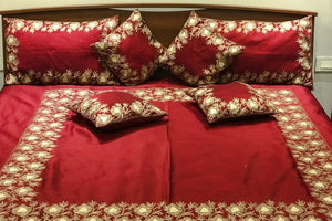 #Maroon Red bedspread with floral patterns on a bed