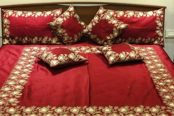 #Maroon Red bedspread with floral patterns on a bed