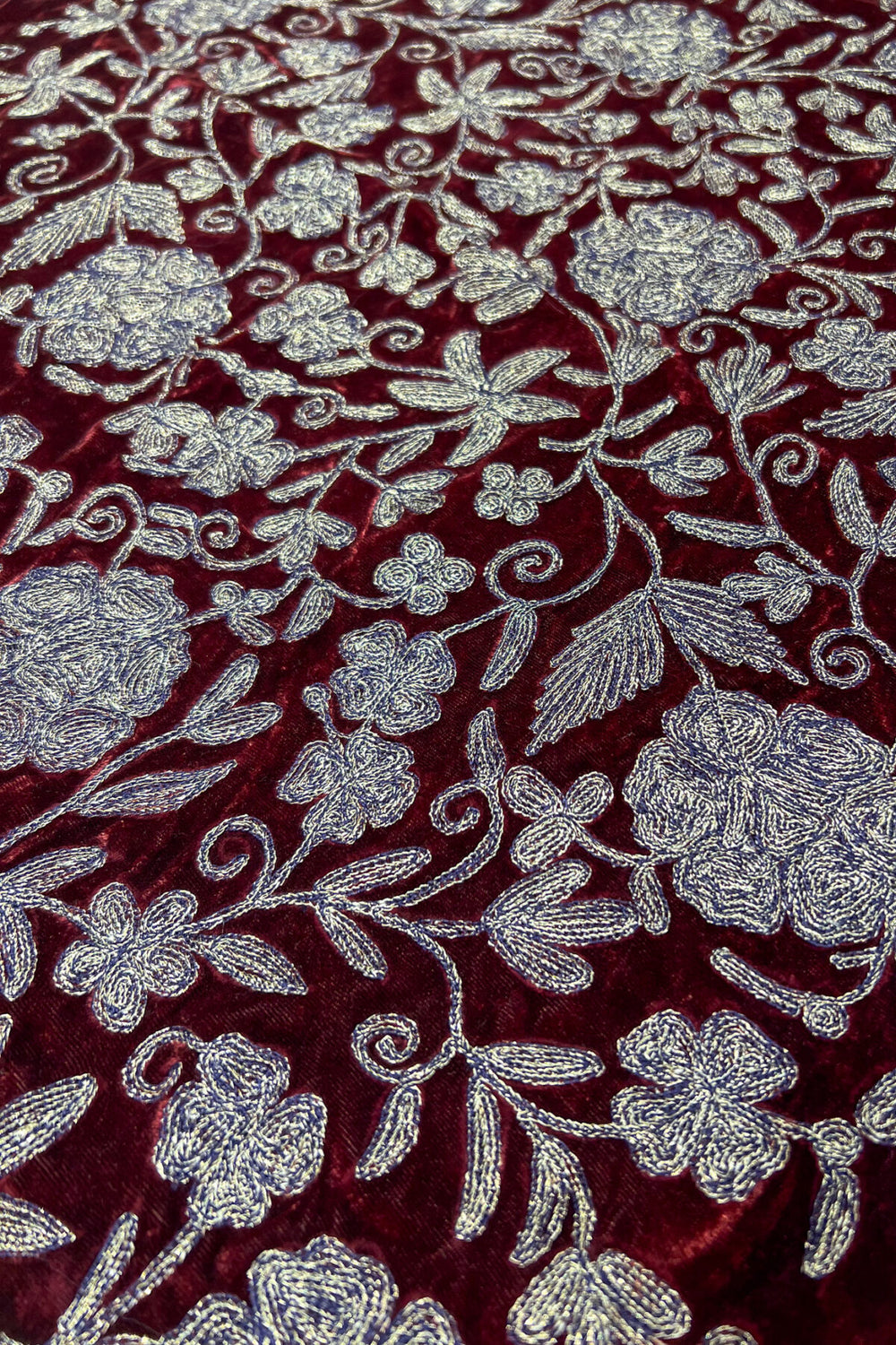 Close-up of red fabric with copper floral embroidery