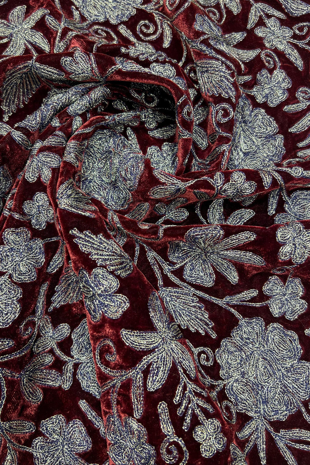 Close-up of red fabric with copper floral embroidery
