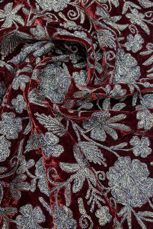 Close-up of red fabric with copper floral embroidery