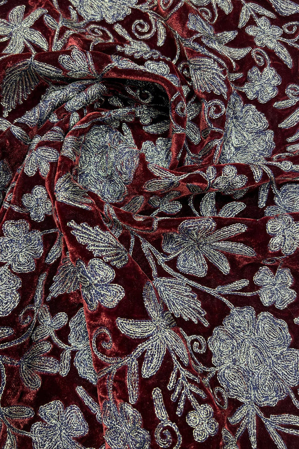 Close-up of red fabric with copper floral embroidery