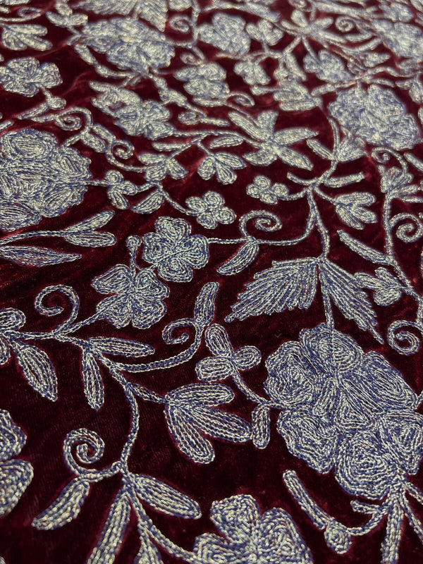 Close-up of floral embroidery on a red fabric background