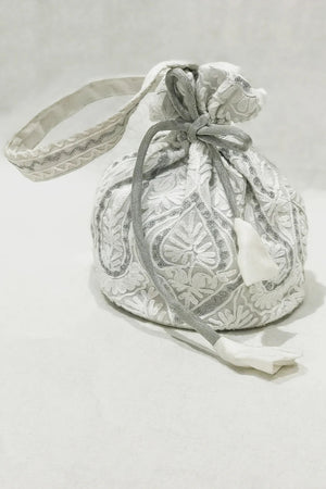 White embroidered drawstring bag on a light gray background
