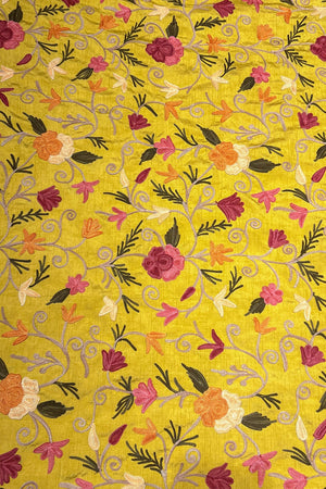 Floral patterned fabric with colorful flowers on a yellow background
