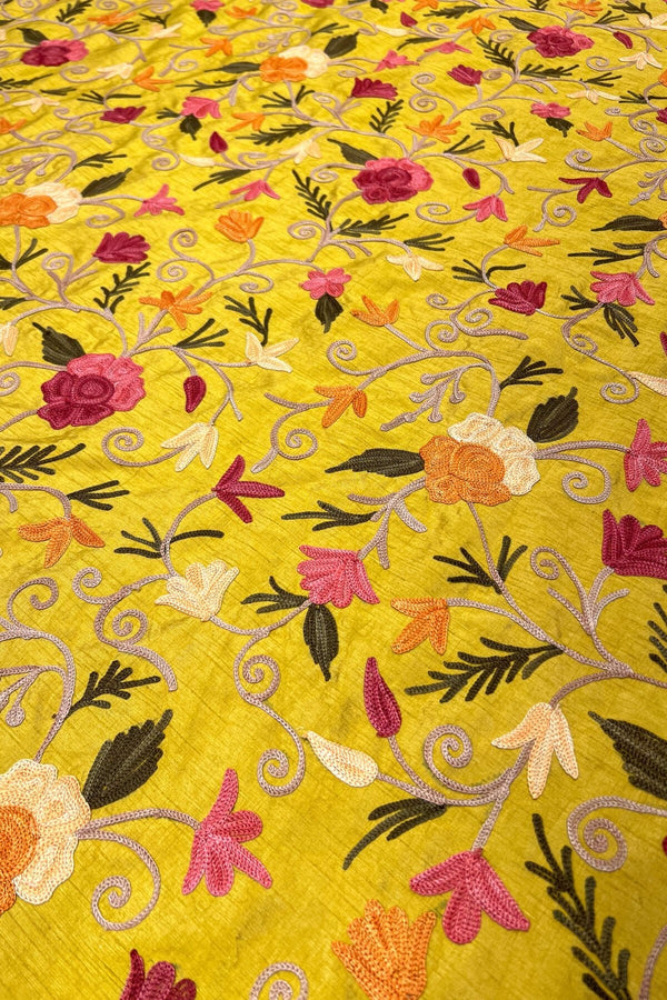 Embroidered fabric with floral patterns on a yellow background