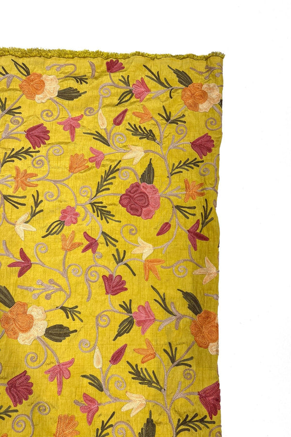 Yellow fabric with floral embroidery on a white background
