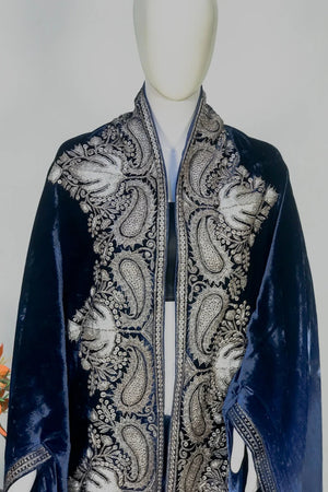 Navy blue velvet cape with intricate silver paisley patterns on a mannequin against a gray background