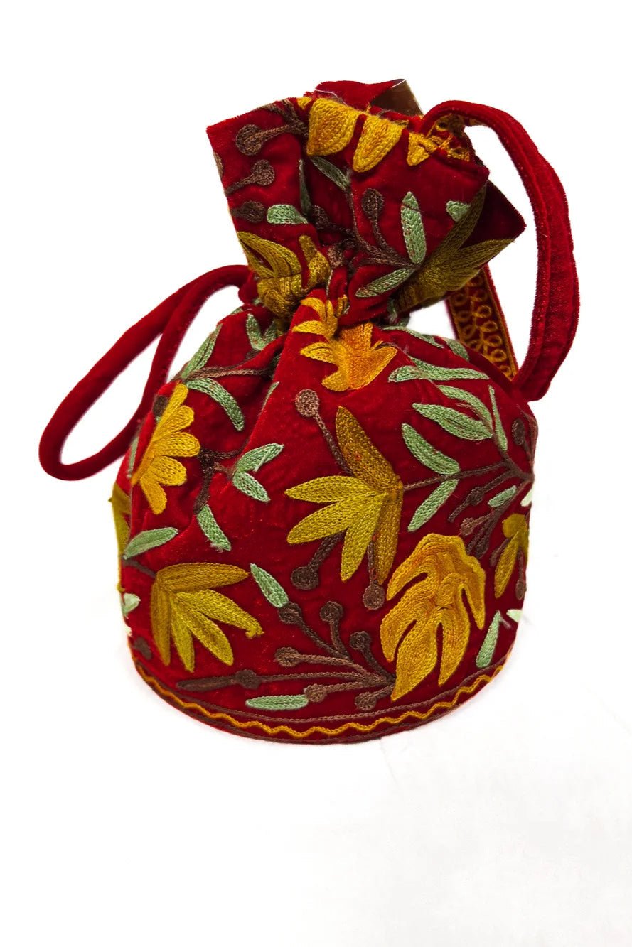 Decorative fabric pouch with floral patterns and red drawstring on a white background