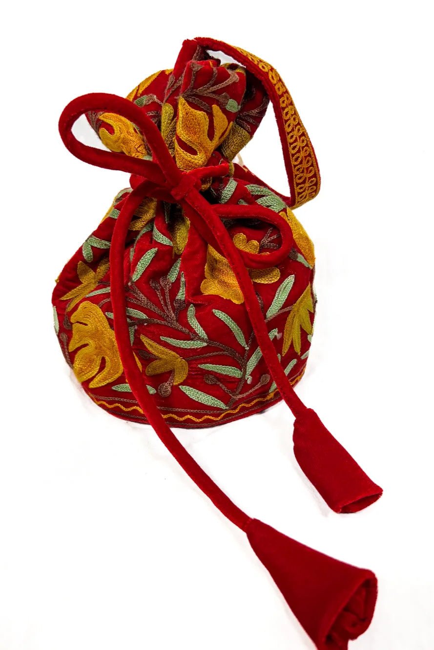 Decorative fabric pouch with floral patterns and red drawstring on a white background
