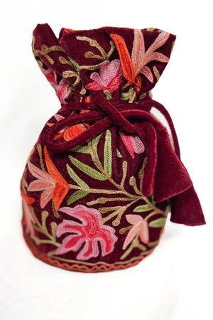 Embroidered fabric pouch with floral patterns on a white background