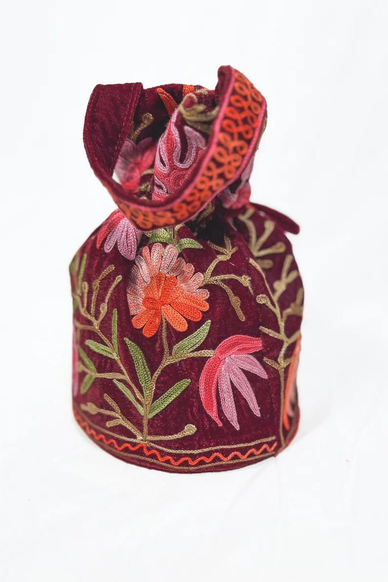 Decorative bag with floral embroidery on a white background