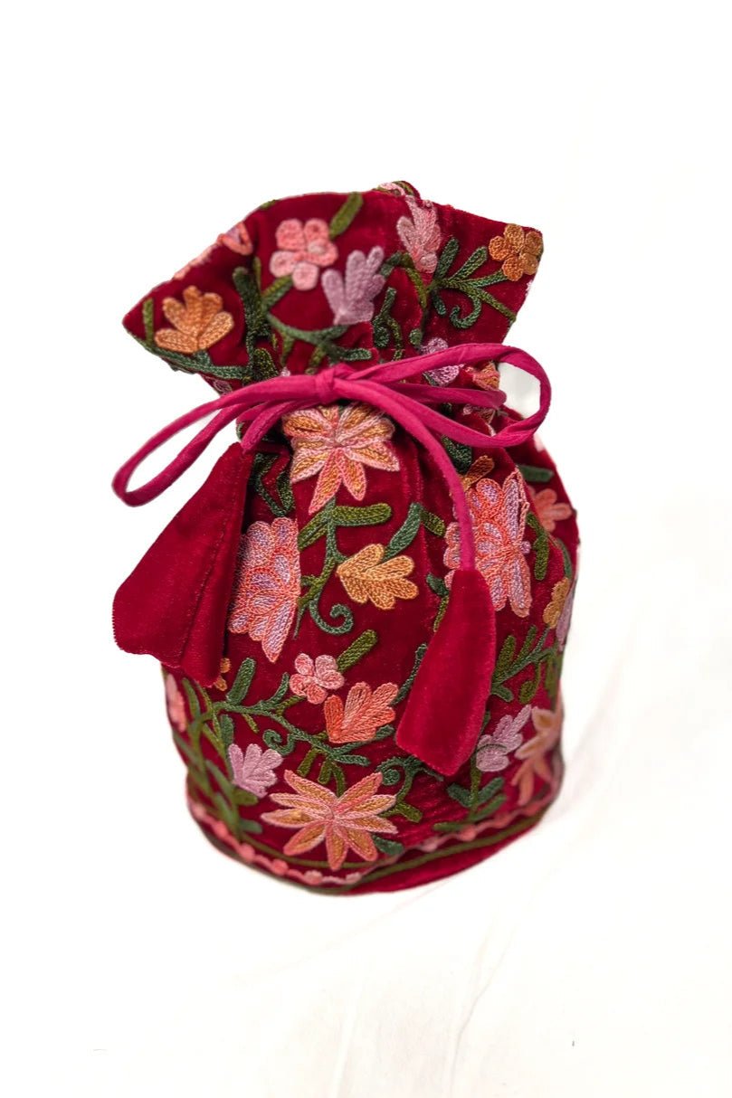 Red fabric drawstring bag with floral embroidery on a white background