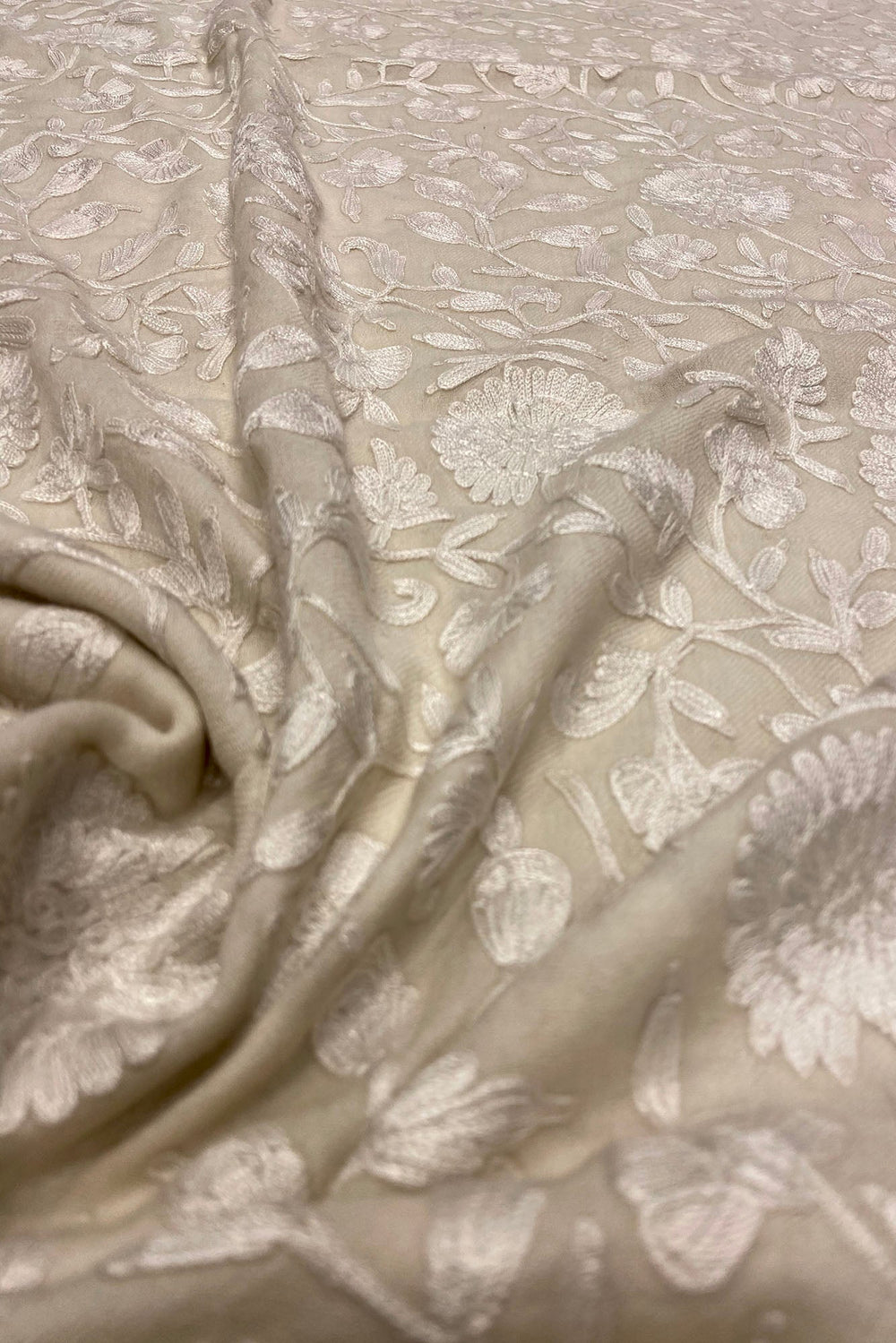 Close-up of off white fabric with floral embroidery