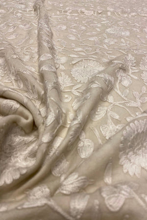 Close-up of off white fabric with floral embroidery