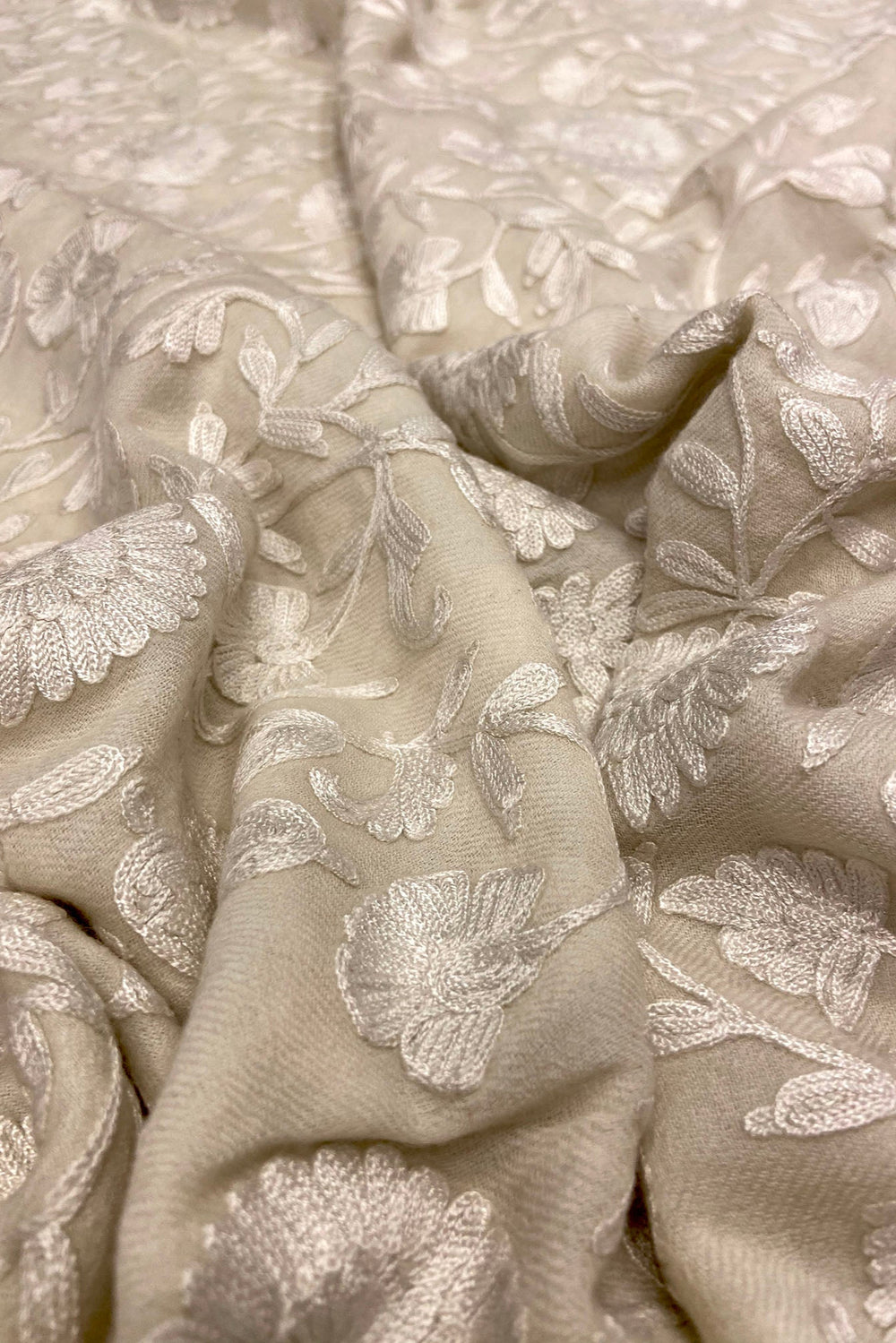 Close-up of off white fabric with floral embroidery